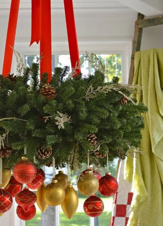 Weihnachtsdeko in Rot und Gold üppiger Weihnachtsschmuck hängt vom Kronleuchter viel Tannengrün Zapfen Anhänger