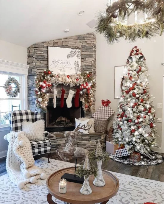 traumhafte Weihnachtsdeko im Wohnzimmer Kamin aus Naturstein hoher Christbaum dekoriert helle Farben dominieren