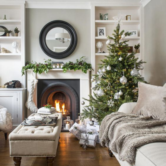 traumhafte Weihnachtsdeko im Wohnzimmer in Beige wenig Schmuck grüner Christbaum Kaminfeuer