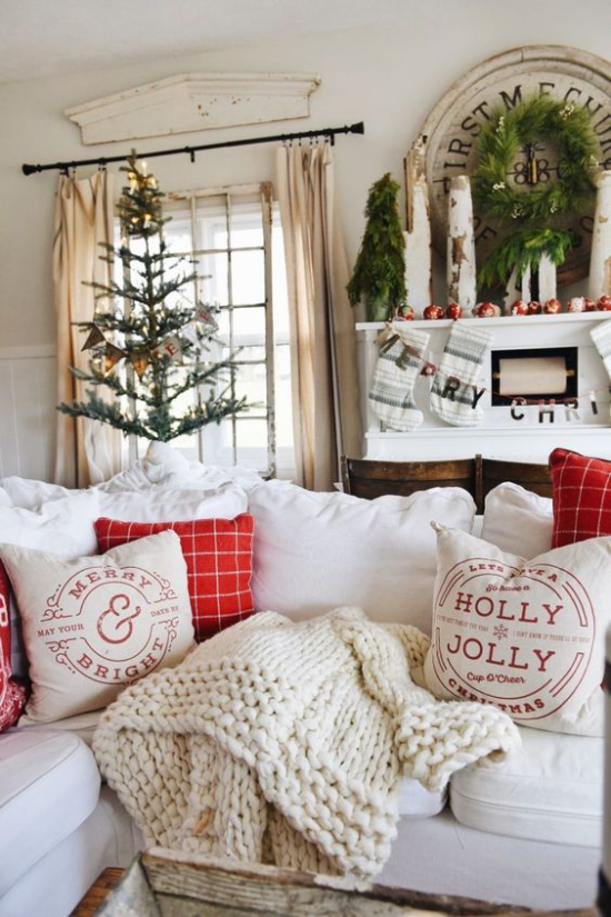 traumhafte Weihnachtsdeko im Wohnzimmer schöne Raumdekoration helle Atmosphäre Christbaum rote Akzente weiche Wurfdecke Kissen