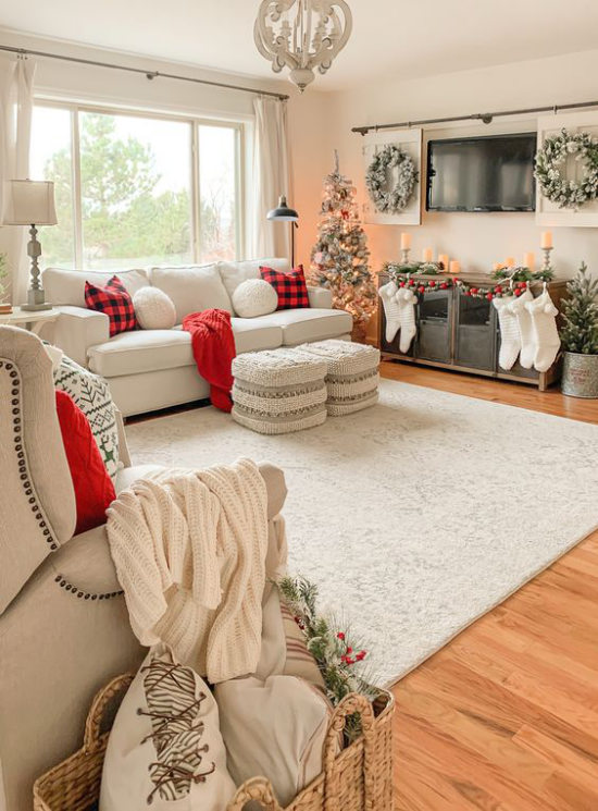traumhafte Weihnachtsdeko im Wohnzimmer weiter Raum in Weiß und Hellbeige geschmückter Christbaum links rote Akzente
