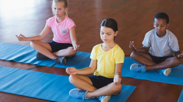School kids meditating during yoga class