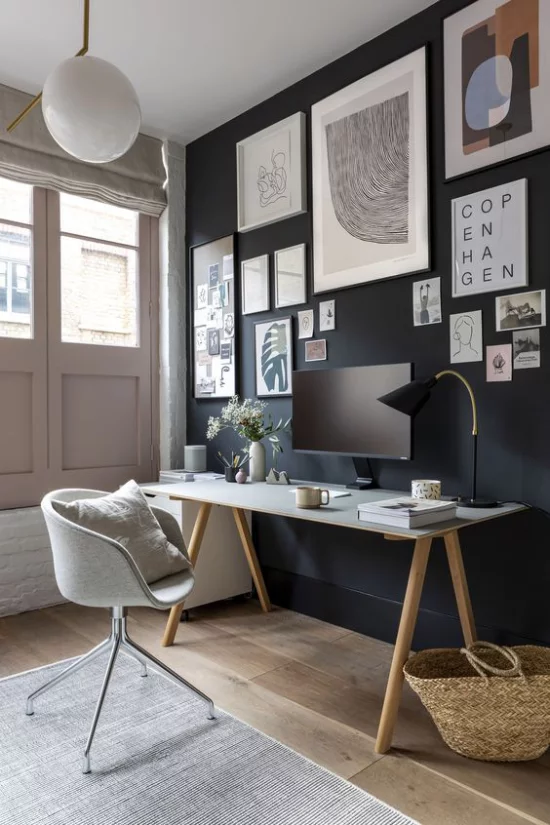 Home Office Guide ansprechende stilvolle Raumgestaltung dunkle Wand über dem Schreibtisch abstrakte Bilder grauer Teppich