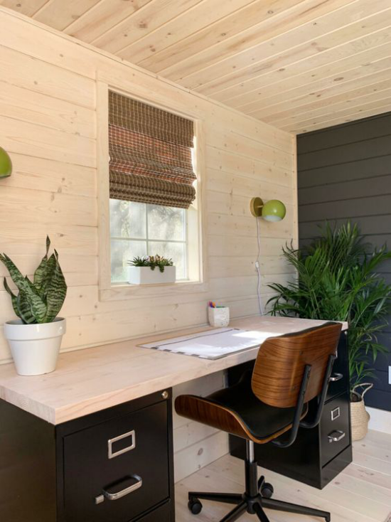 Home Office im Landhausstil immergrüne Zimmerpflanzen erfrischen das Ambiente großer Schreibtisch Stuhl Fensterrollo