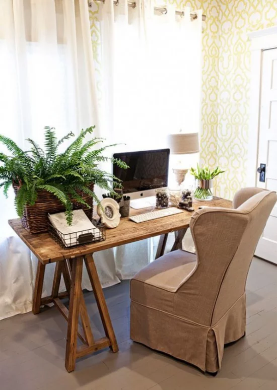 Home Office im Landhausstil üppiges Grün Farn im Kasten auf dem Schreibtisch Sessel in Beige viel Tageslicht