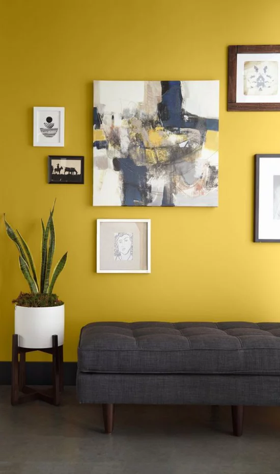 Trendfarben 2021 im Interieur Wohnzimmer graue Liege gelbe Akzentwand Gemälde ein guter visueller Ausgleich