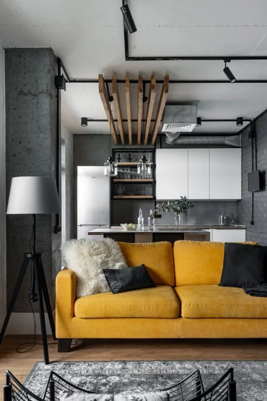 Trendfarben 2021 im Interieur graue Wohnküche Industrial Style gelbes Sofa Blickfang