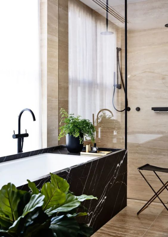 Badezimmer Trends 2021 Badewanne außen schwarzer Marmor Fenster exotische Grünpflanze auffälliger Look