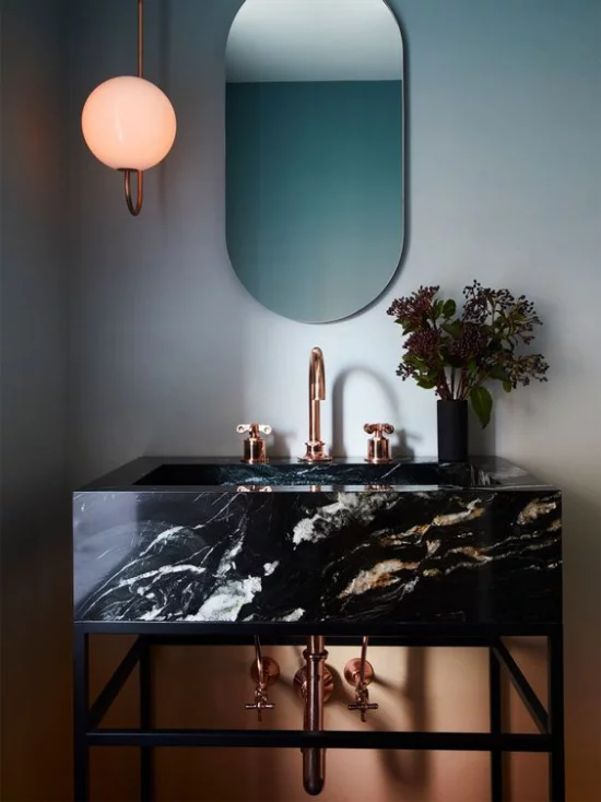 Badezimmer Trends 2021 moderner Waschtisch aus schwarzem Marmor interessante Maserung Badarmatur aus Bronze