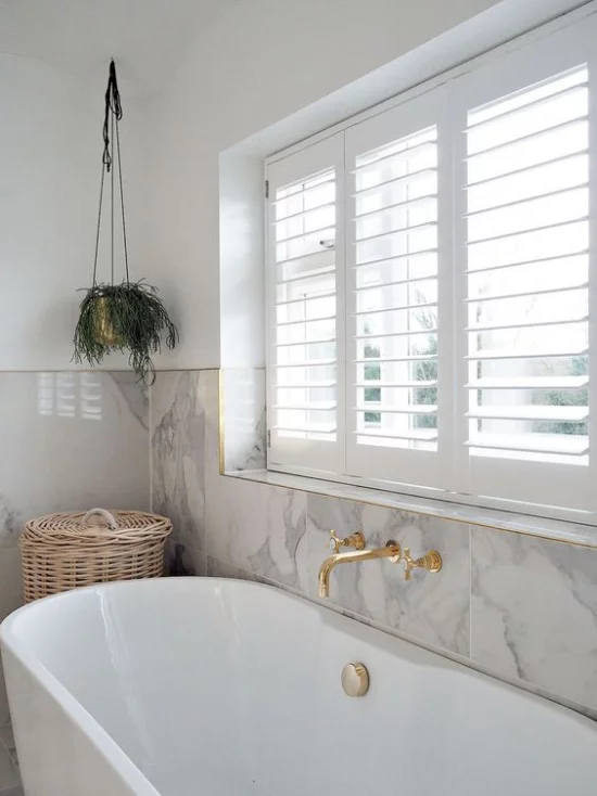 Badezimmer Trends 2021 weiße Badewanne großes Fenster weißer Marmor an der Wand