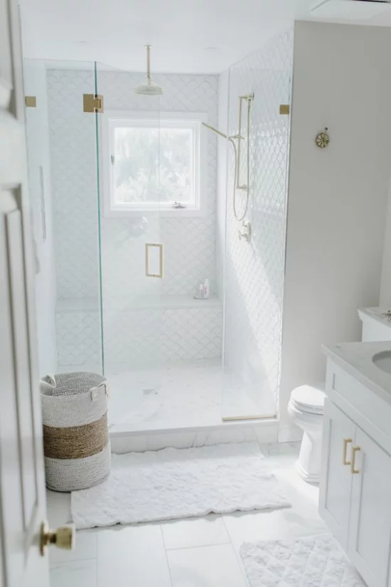 Badezimmer Trends 2021 weißes Baddesign Sauberkeit Eleganz Stil Duschecke Glastür Badematten Korb