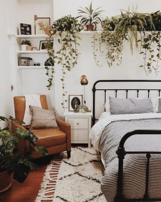 Frühlingsdeko Ideen fürs Schlafzimmer den ganzen Raum begrünen viele grüne Topfpflanzen auf Regal über dem Schlafbett