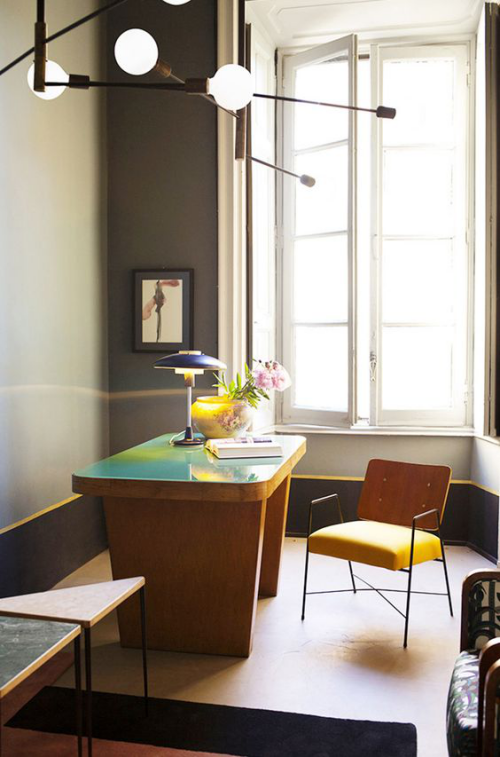 gelbe Akzente im Home Office Büro Inspiration großes Fenster gerundeter Schreibtisch Stuhl  Tischlampe runde Vase mit Blumen visuelle Balance