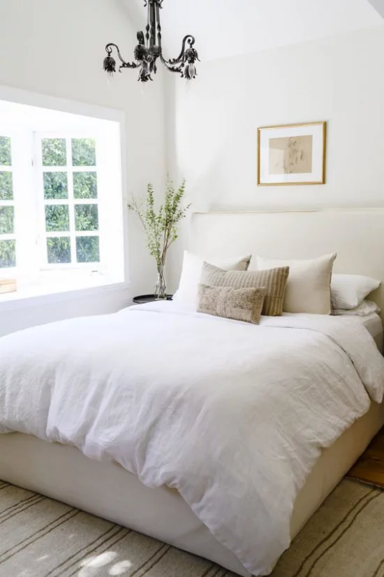 kleines Schlafzimmer optisch erweitern großes Fenster viel Tageslicht bequemes Bett weiße Bettwäsche