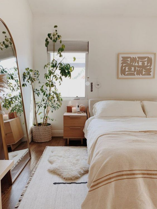 kleines Schlafzimmer optisch erweitern schönes Ambiente helle gedeckte Farben Topfpflanze in der Ecke vor dem Fenster Spiegel links