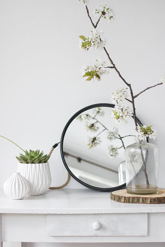 skandinavische Frühlingsdeko Spiegel blühende Zweige weiße Wohnaccessoires