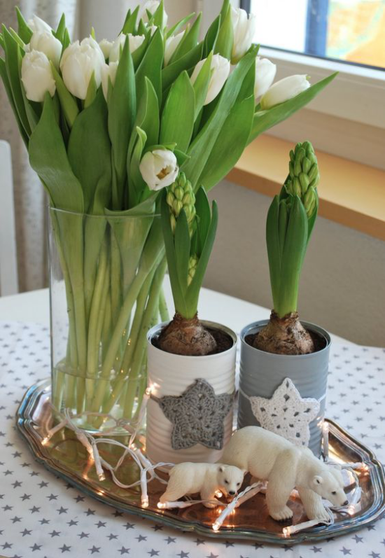 skandinavische Frühlingsdeko auf dem Esstisch weiße Tulpen Hyazinthen kleine Bärenfiguren
