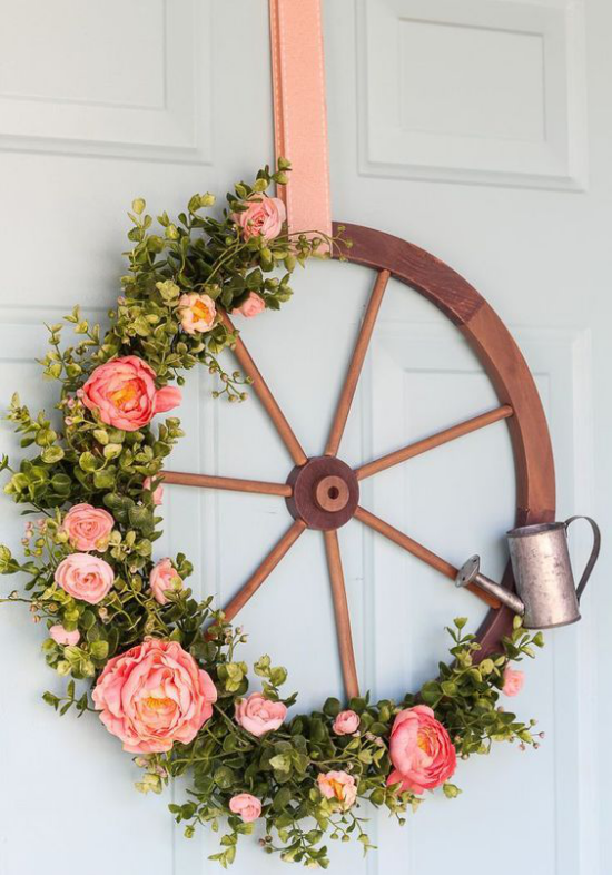 Frühlingskränze altes Rad geschmückt an der Haustür rustikaler Look viel Grün schöne Blüten