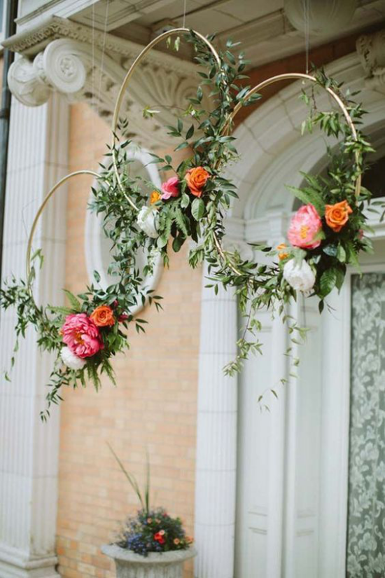 Frühlingskränze dünne Metallreifen vor der Haustür gehängt mit Blüten und Grün geschmückt ausgefallene Deko