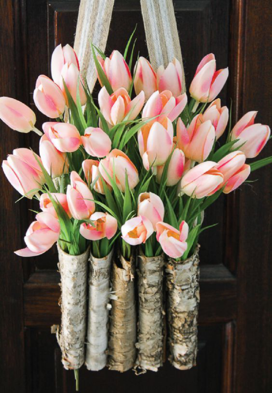 Frühlingskränze kleine Blumenbehälter aus Birkenrinde an der Haustür voller rosafarbener Tulpen