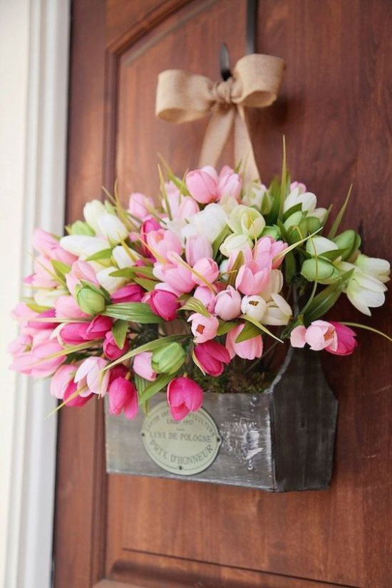 Frühlingskränze schöne rosa Tulpen im alten Holzkasten an der Haustür