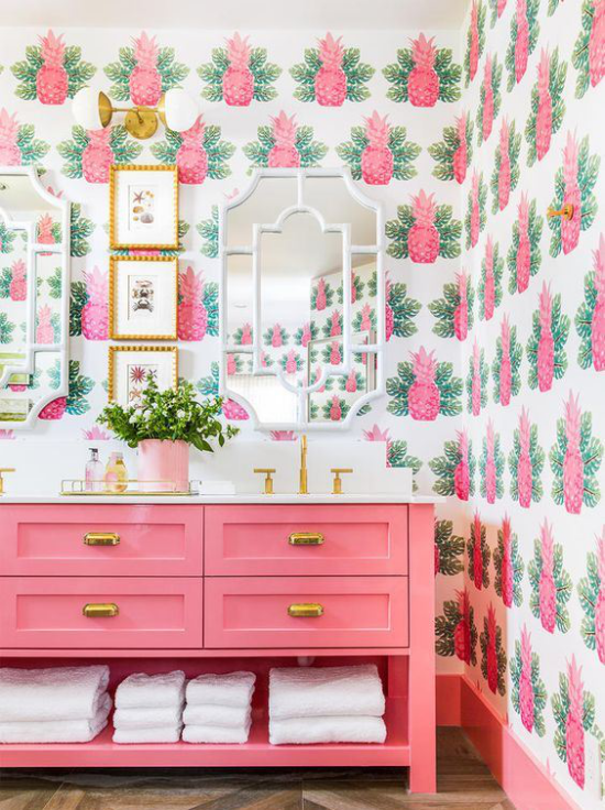 Tropische Deko im Bad Tapetenmuster Ananas Blätter exotischer Look Spiegel Bilder rosa Schrank weiße Badetücher