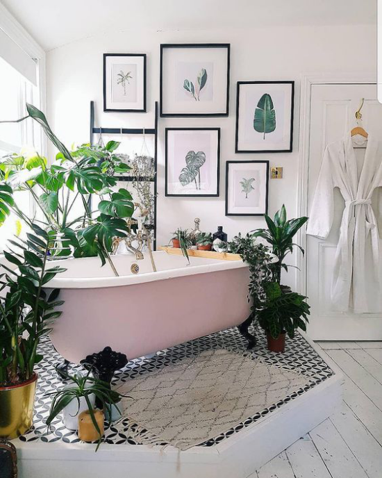 Tropische Deko im Bad freistehende Badewanne mit Löwenfüßen umgeben von grüßen Topfpflanzen Wanddeko Bilder große exotische Blätter