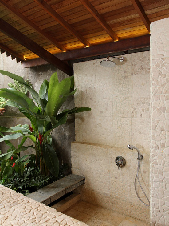 Tropische Deko im Bad üppige grüne Pflanzen große Blätter viel Naturstein Holz schönes Ambiente