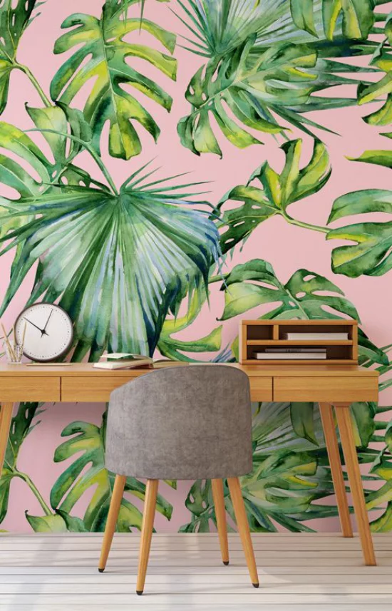 Tropische Deko im Home Office schöne Raumatmosphäre Schreibtisch aus Holz Bürosessel Uhr Akzentwand tropische Muster auf Tapete