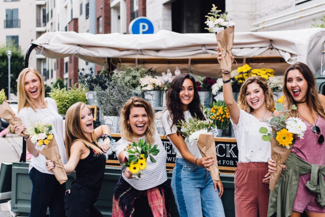 Weltfrauentag am 8.März junge Frauen mit Blumensträußen in der Hand feiern den 8. März