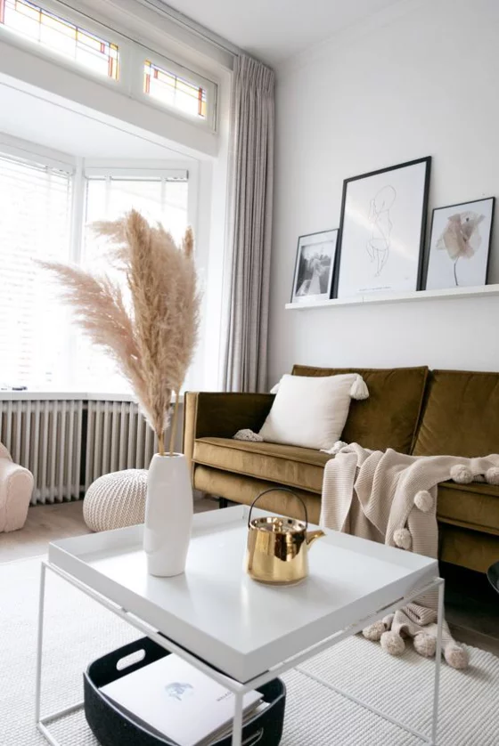 Erkerfenster Wohnzimmer in warmen Farbtönen bequemes Sofa Raumdeko aus Naturmaterialien