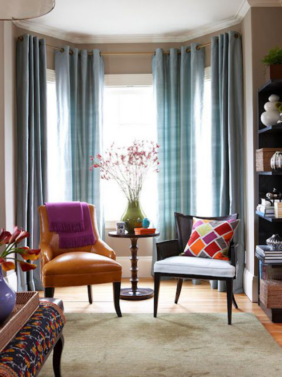 Erkerfenster schön eingerichtetes Wohnzimmer leichte blaue Gardinen Ledersessel bunte Raumgestaltung