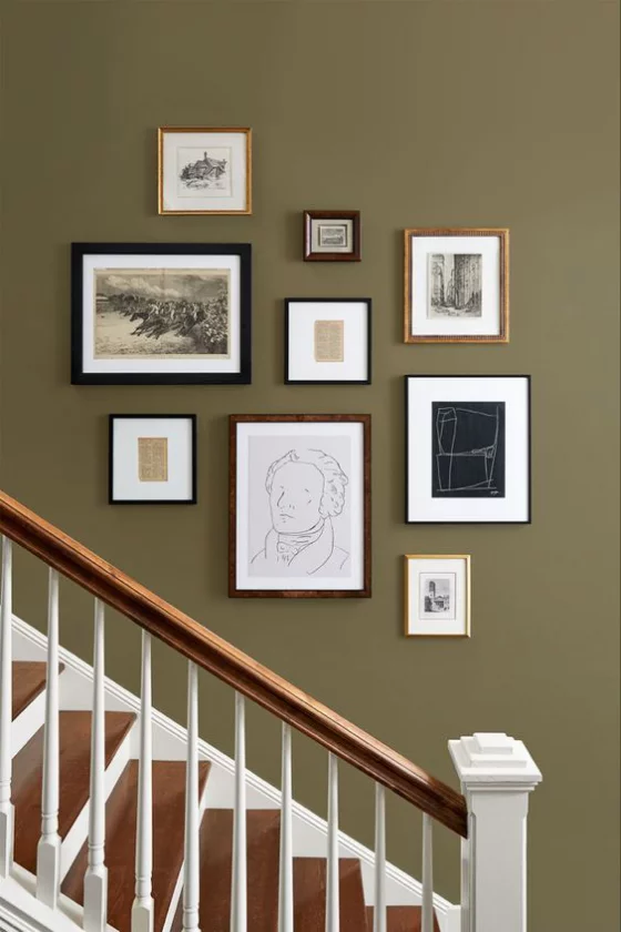Fotowand im Treppenhaus dunkler Hintergrund Bilder in verschiedenen Größen Rahmen auffällige kreative Gestaltung