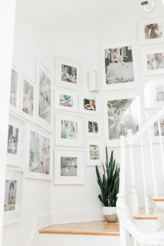 Fotowand im Treppenhaus in der Ecke schöne großformatige Bilder in weißen Rahmen unter Glas
