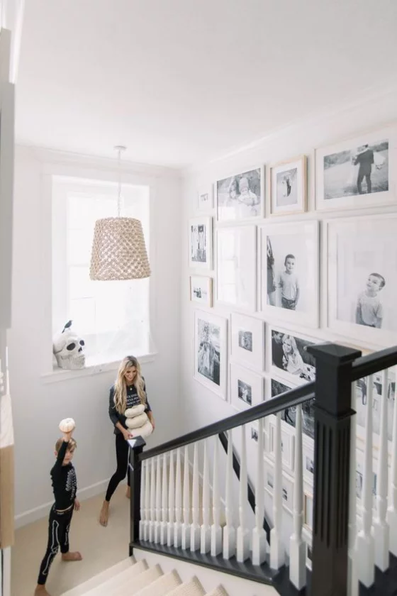 Fotowand im Treppenhaus viele Bilder in weißen Rahmen Mutter Sohn auf der Treppe