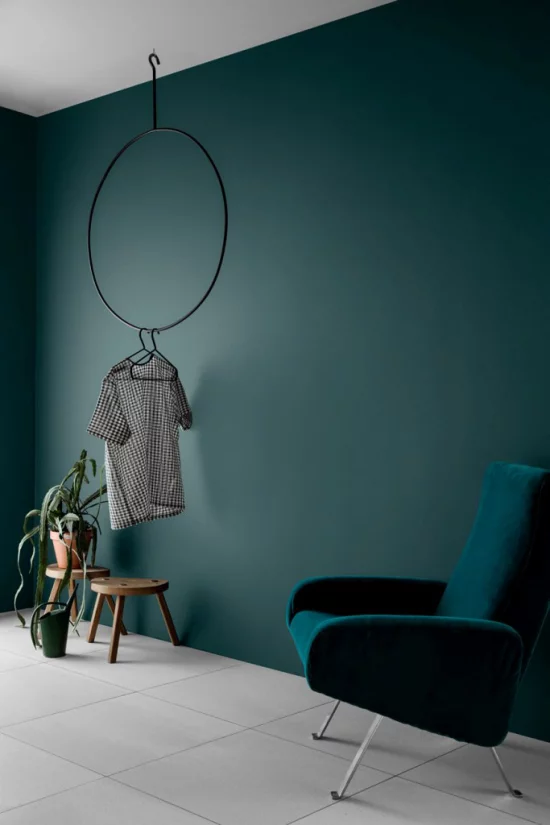 Mehr Farbe ins Interieur bringen gesättigte Farben Dunkelblau Wand Sessel grauer Boden starke optische Ausstrahlung