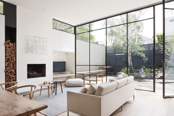 Open-Air-Wohnzimmer mit deckenhohen Glaswänden und bequemem Sofa