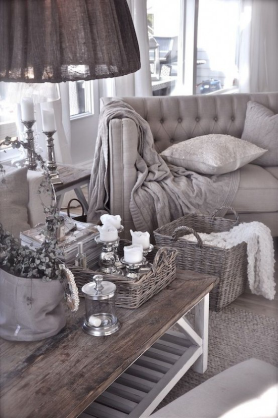Provence-Stil Grau dominiert Sessel Tisch ländliches Tablett weiße Kerzen dunkle Lampe graue Wurfdecke