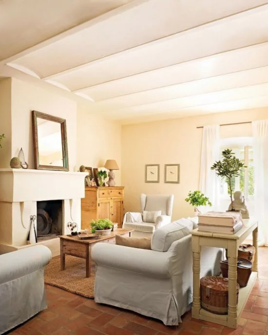 Provence-Stil lichtdurchflutetes Wohnzimmer Sandfarben viel Holz weiße Bezüge der Sitzgarnitur Kamin