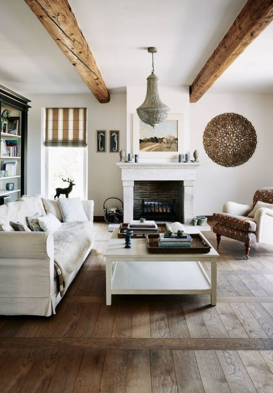 Provence-Stil ländliches Wohnzimmer kahler Boden Holzbalken an der Decke Raumaccessoires aus Naturmaterialien typisch für den französischen Landhausstil