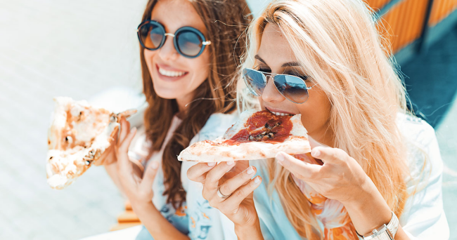 Regel zwei junge Frauen Pizza essen fröhlich sein lachen