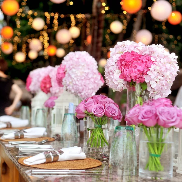 Rosa Hortensien Tischdeko rosa Rosen und Hortensien in Vasen arrangiert in der Mitte des Tisches bei Hochzeitsfeier