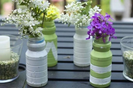 DIY Vasen aus Plastikflaschen auf dem Tisch voller Blumen