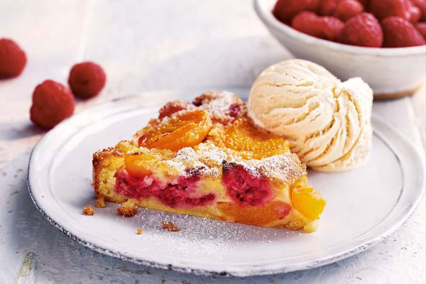 Aprikosenkuchen ein Stück Kuchen mit Aprikosen und Himbeeren mit Eis serviert unwiderstehliches Sommerdessert