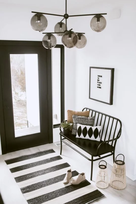 Farbpaare schicke Gestaltung im Flur in schwarz-weiß kleiner Läufer gestreift Sitzbank schwarze Eingangstür