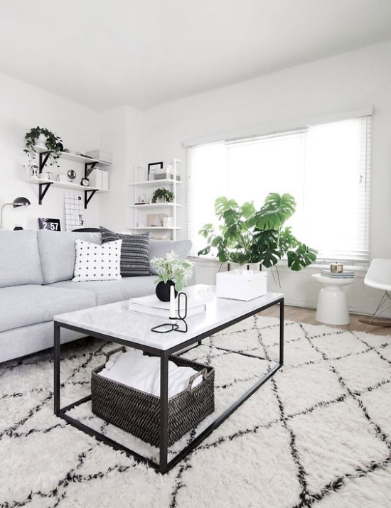 Farbpaare schönes Wohnzimmer in Schwarz und Weiß Sofa Tisch Teppich grüne Topfpflanzen frische Note