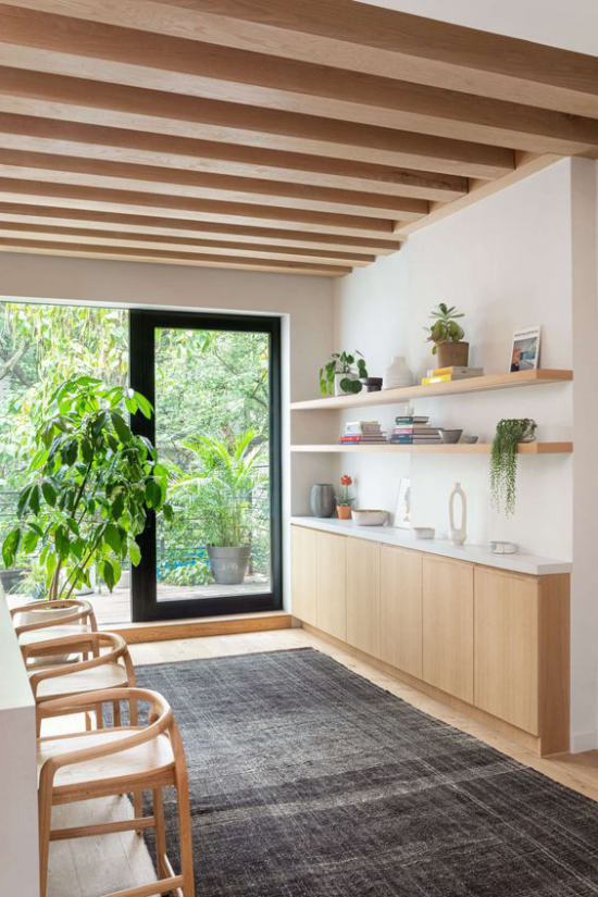 Helles Holz im Interieur Küchenzeile modernes Raumdesign Blick in den Hinterhof viel Grün Holzbalken