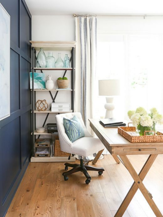 Home Office maritim einrichten Holzboden Schreibtisch weißer Bürostuhl weiße Hortensien dunkelblaue Schränke