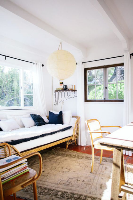 Home Office maritim einrichten einfaches Raumdesign weißes Sofa marineblaue Kissen Teppich Holztisch Stuhl gestapelte Bücher