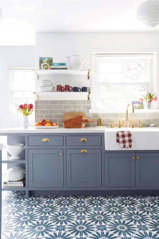 Küchenzeile in Retro Stil gemusterte Bodenfliesen in Blau Pastellblaue Unterschränke Fenster viel Licht bunte Farbtupfer Obst